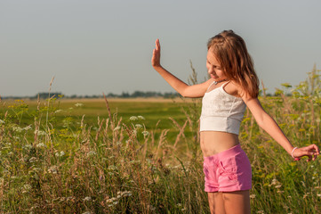 Child girl on the background of the summer field.