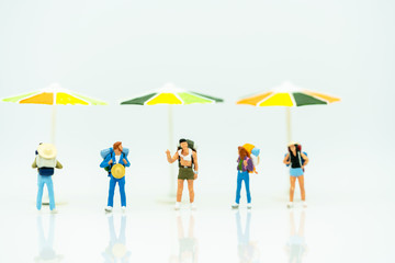 Miniature people: Tourists  with backpack standing on the beach. Summer Concept.