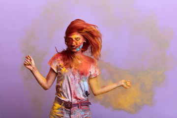 pretty girl dancing among colourful smoke. close up portrait, isolated blue background, studio shot