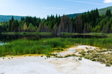 Polluted lake with kaolin on abandoned quarry with beautiful blue sky in Harghita Bai, Romania.