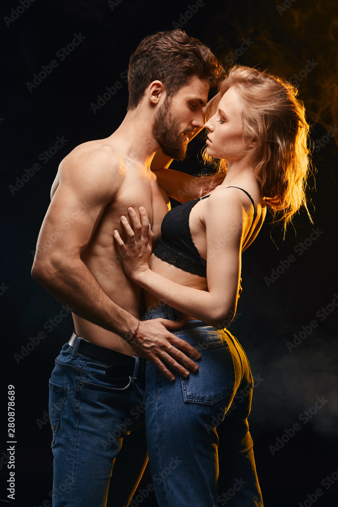 Wall mural unforgettable moment. tender passion between young people.close up portrait. isolated black background