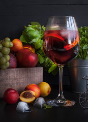 Sangria red wine or punch with fruit and ice in glasses. Homemade refreshing sangria fruit on a rustic wooden table. Spanish cuisine.