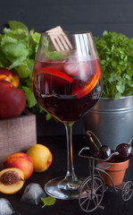 Sangria red wine or punch with fruit and ice in glasses. Homemade refreshing sangria fruit on a rustic wooden table. Spanish cuisine.