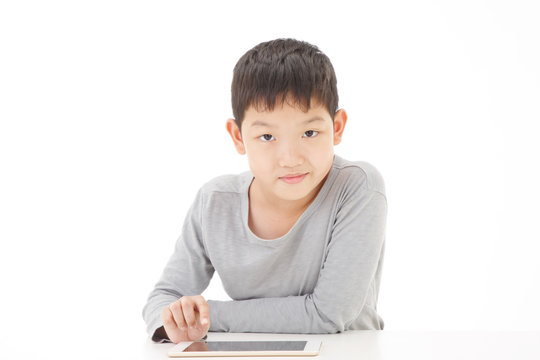 Asian boy using tablet computer isolated on white background. Look at Camera Pose.