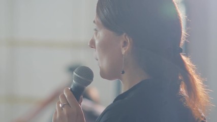 Speaker is giving speech at business event. Adult businesswoman in modern conference hall. Business and entrepreneurship seminar.