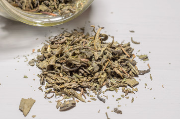 Fototapeta na wymiar dried green tea leaves on wooden background