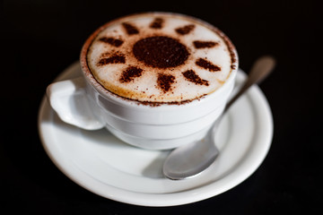Cappuccino cup with cocoa on a black background