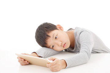 Asian boy using tablet computer isolated on white background.Feel Sleepy.