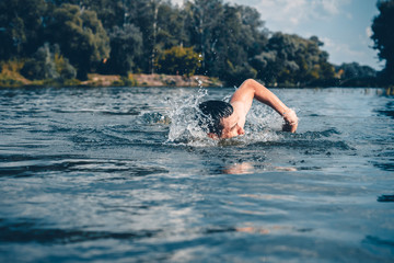 The young man swimming in the river