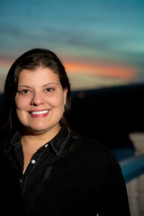 Lady portrait outdoors during blue hour. She is smiling and looking to the camera.