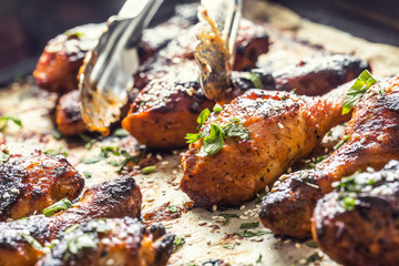 Grilled hicken legs BBQ with spices herbs and sesame on baked paper. Roasted poultry meal in roaster dish