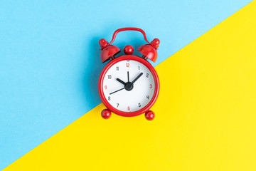 Time, deadline or timer and reminder concept, flat lay of red retro alarm clock on contrast color yellow and blue. background