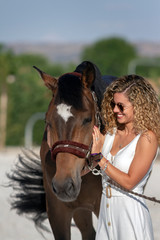 Fototapeta premium blonde girl stroking a horse