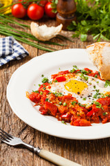 Shakshouka, dish of eggs poached in a sauce of tomatoes, chili peppers, onions