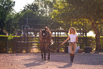 blonde girl walking with a horse