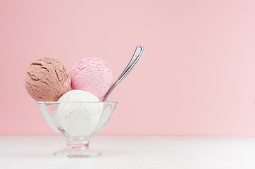 Set of vanilla ice cream scoops different flavor - strawberry, chocolate, creamy in elegant bowl with silver spoon in modern stylish pastel pink interior.