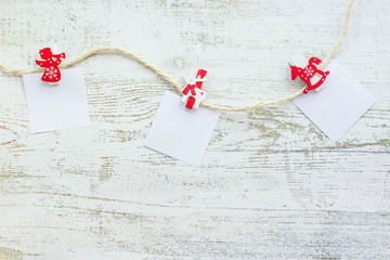 New year concept. Wooden christmas decorations and blank white sheets of paper for text on light wooden background. Top view, flat lay composition.