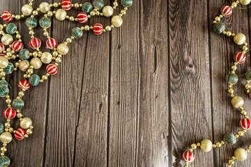 New year concept. Colorful Christmas beads on dark wooden background. Top view, flat lay composition.