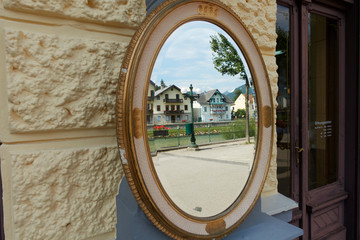 Mirror in front of a shop in which the facade of old houses of Bad Ischl is reflected