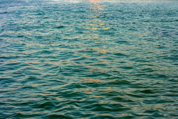 Small waves of the cold Black Sea in the rays of the setting sun.Texture water background