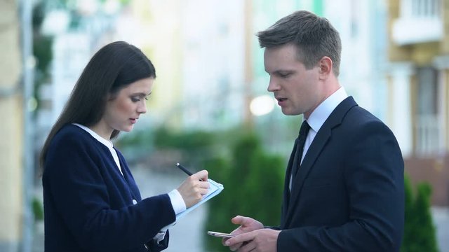 Female secretary recording in notebook male boss orders, personal assistant