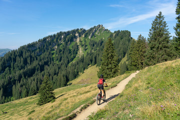 Fototapeta na wymiar nice, active senior woman underway with her electric mountain bike in the Allgaeu Alps near Oberstdorf, Bavarian Alps, Germany