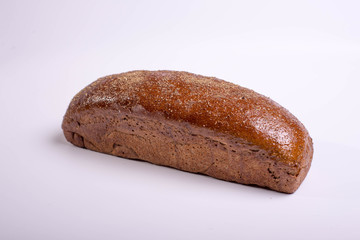 Long brown bread on a white background with crispy cumin and spices