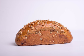 Long black bread with seeds. Baking on a white background