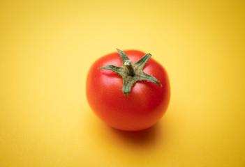 rote Tomate auf gelbem Untergrund