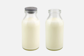  Fresh milk in a transparent bottle with and without lid, isolated on white background, Perspective