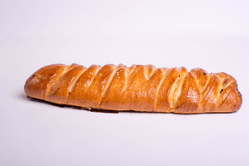 Dessert in the form of a poppy seed roll on a white background. Tasty golden pastry