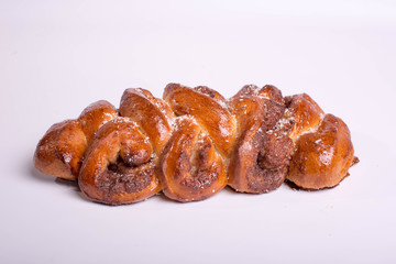 Baking with poppy seeds. Poppy roll in the form of a pigtail. Golden baked roll on a white background