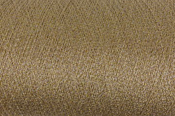 background of golden and white lurex wool on a cone