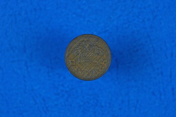 old brown denmark coin lying on a blue background