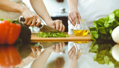 Fotobehang Closeup of human hands cooking in kitchen. Mother and daughter or two female friends cutting vegetables for fresh salad. Friendship, family dinner and lifestyle concepts © rogerphoto