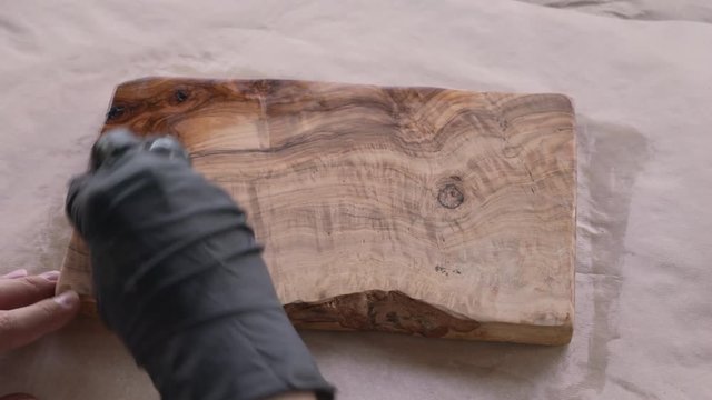 woodworker applying oil finish to olive wood board