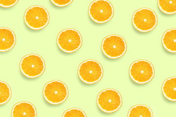 Colorful fruit pattern of fresh orange slices on colored background. Orange slices top view.