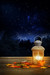 autumn lantern on wood table at night