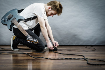 Man adjusting guitar effects pedal - obrazy, fototapety, plakaty