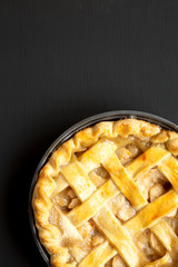 Homemade apple pie on a black wooden background, top view. Flat lay, overhead, from above. Copy space.