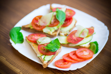 tasty sandwich with curd paste, fresh cucumbers and tomatoes