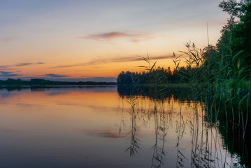 Fototapeta na wymiar Reflections on the calm waters of the Saimaa lake in Finland at Sunset - 5