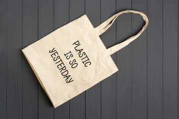 eco - friendly non - woven bag on a dark gray wooden background Plastic is yesterday Top view Flat...