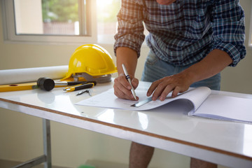 architect man handwriting with blueprint to build houses. After agreeing the employment price the...