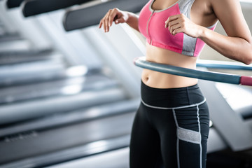 Young woman ratating hoola hoop in the gym © Seksan