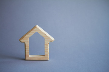 Obraz na płótnie Canvas Wooden figure of house on gray background, the concept of buying or renting building, eco friendly to environment, selective focus