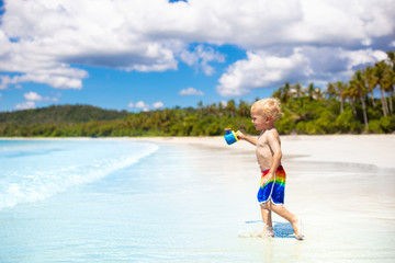Naklejka premium Kids play on tropical beach. Sand and water toy.