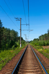 Single track railway line on a clear sunny day. Perspective view