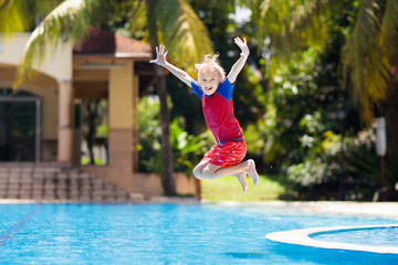 Child in swimming pool. Summer vacation with kids.