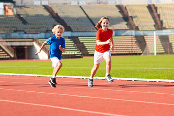Child running in stadium. Kids run. Healthy sport.